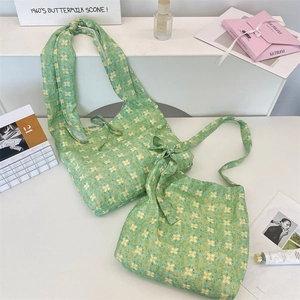 Detail of green floral canvas tote bag featuring ribbon tie strap and inner storage space