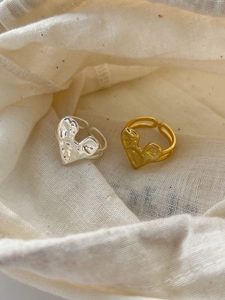 Dettaglio di anelli a cuore in argento sterling 925 con texture martellata oro e argento