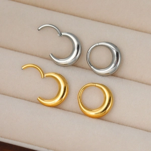 Close-up of silver and gold 316L stainless steel crescent hoop nose rings in a velvet box