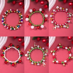 Christmas charm bracelet set with bells and snowflakes on festive red background