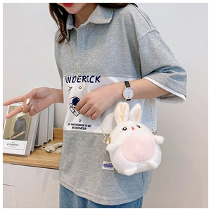 Detailed shot of white plush rabbit crossbody bag with pink details and gold chain strap