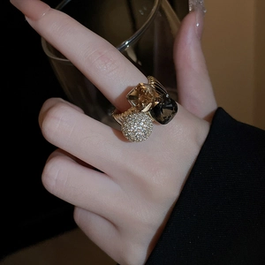 Close-up of gold plated ring set with amber and black square zircons on model's hand