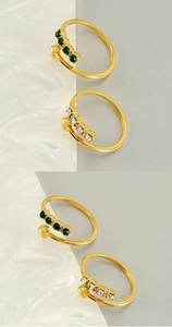 Detailed shot of adjustable gold rings with green and white gemstones in close-up