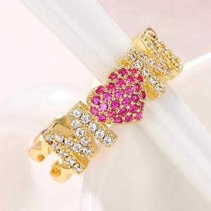 Macro detail of gold MOM ring featuring pink pavé heart and sparkling white crystals