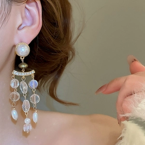 Detailed close-up of gold tassel earrings with pearls and crystals in court style