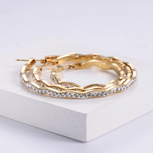 18K gold plated wavy hoop earrings with zircon pavé setting on white pedestal
