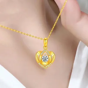 Detail shot of heart-shaped gold-plated pendant necklace with white crystals on a model