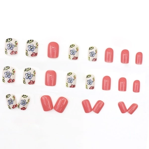 Floral press-on nails set with creamy white hand-painted flowers and coral pink glossy tips