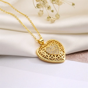 Macro shot of gold hollow heart pendant with sparkling cubic zirconia on white silk