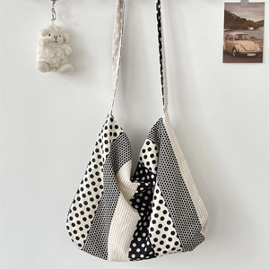 Detail of canvas tote bag with black and white polka dots and cute plush sheep charm