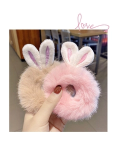 Close-up of soft plush rabbit ear hair scrunchies in pink and khaki faux fur textures