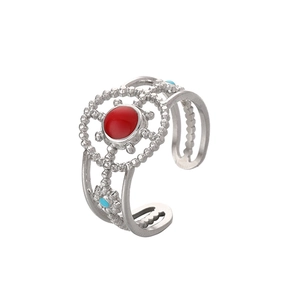 Detailed macro view of silver open ring with red stone and blue enamel accents
