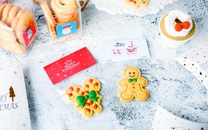 Flat lay of assorted Christmas themed sugar cookies with a Merry Christmas holiday card