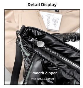 Detail of black glossy puffer bag showing smooth metal zipper and silver round puller