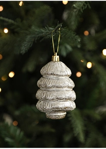 Dettaglio di un addobbo natalizio a forma di albero d'argento appeso a un ramo