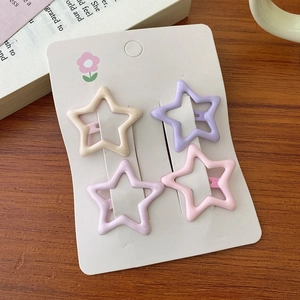 Detailansicht von 4 sternförmigen Haarspangen in Pastellrosa und Lila auf Displaykarte
