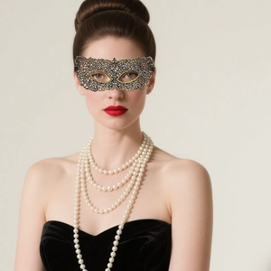 Detail of black and gold lace masquerade mask paired with layered pearl necklace