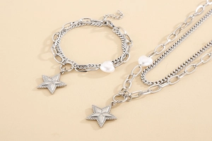 Detail of silver star pendant necklace set with white heart pearl and mixed chain link