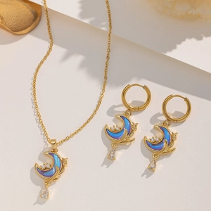 Detailed shot of golden moon necklace and earrings set with purple zircon and water drops
