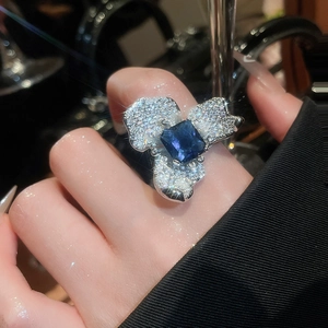 Détail d'une bague fleur avec pierre carrée bleu foncé et zircons étincelants