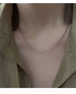 Close-up of fine S925 sterling silver Italian snake chain worn on the neck