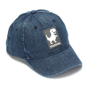 Close-up of dark blue denim baseball cap featuring a pixelated dinosaur patch and stitching
