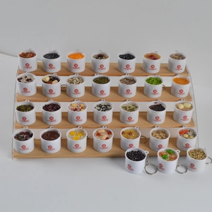 Miniature assorted Chinese rice porridge keychains on a tiered display stand
