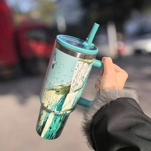 Detail of insulated travel mug with handle and hand-painted coastal cliff scenery print