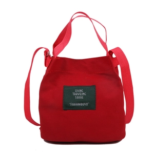 Minimalist red canvas bucket bag with dual handles and crossbody strap for women