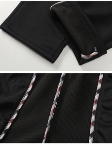 Detail of men's sports pants featuring mesh lining and red-white-black plaid hem piping