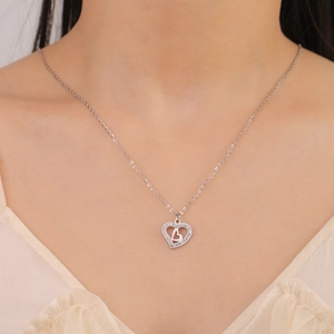 Polished silver double heart pendant necklace with shimmering crystals on model