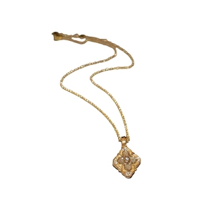 Vintage gold plated four leaf clover necklace with crystal inlay on white background