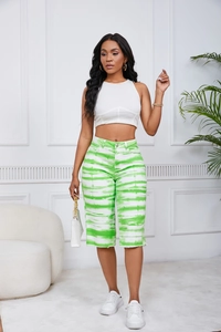 Detailed view of green and white tie-dye denim shorts and white halter crop top
