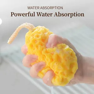 Soft honeycomb bath sponge with hanging rope producing rich lather in hand close-up