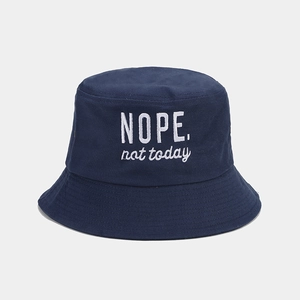 Detail view of the 'NOPE. not today' white embroidery on a navy cotton bucket hat