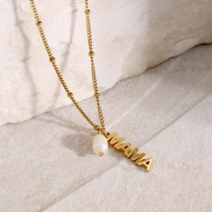 Detailed macro view of 18k gold MAMA pendant with natural freshwater pearl and beaded chain