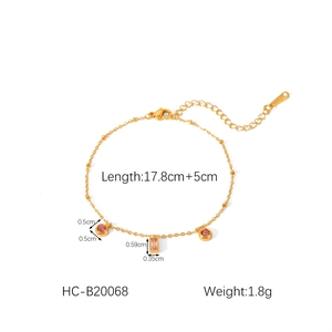 Detail of gold stainless steel bracelet with pink cubic zirconia charms and size labels