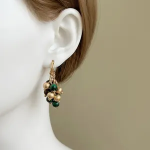Elegant gold drop earrings with tiger eye stone beads and frosted golden beads on a model
