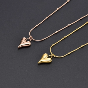 Polished 18K gold and rose gold heart necklaces with snake and bead chain layers