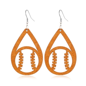 Close-up of teardrop wooden earrings with hollow baseball pattern on a white background
