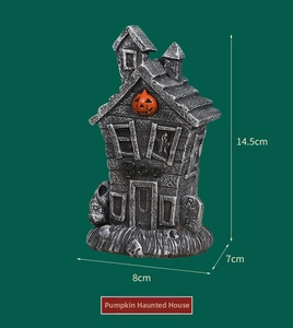 Detail view of resin pumpkin haunted house with RIP gravestone and Boo carving