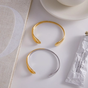 Close-up of minimalist two-tone and gold-plated stainless steel open bangles