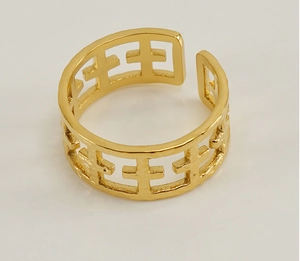 Detailed macro view of the gold-plated geometric hollow patterns on an open metal ring