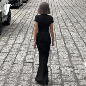 Street view of black long dress with elegant draping and sleek back profile design