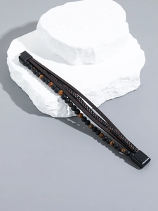 Detail of handmade obsidian and tiger eye beads with dark brown braided leather cord