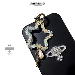 Detail of star-shaped beaded phone charm with pearl pendant and elastic spiral cord