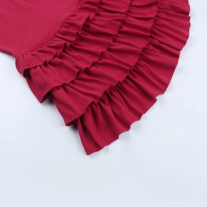 Detailaufnahme der roten gestuften Rüschen am schulterfreien Kleid aus Textilgewebe