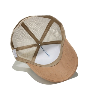 Detail view of khaki trucker hat interior with breathable mesh and adjustable strap