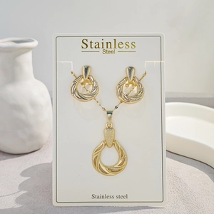Golden stainless steel teardrop pendant necklace and matching earrings on display card