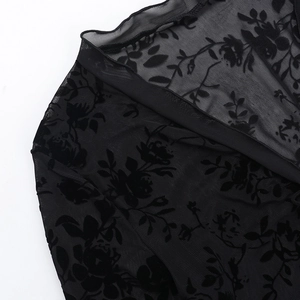 Detailed close-up of black mesh fabric with elegant 3D rose floral flocking texture
